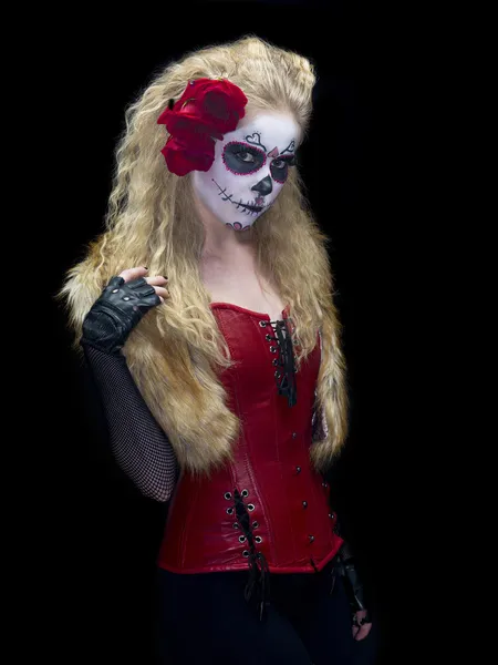 Retrato tiro de uma fêmea vestindo assustador açúcar crânio make-up enquanto posando sobre fundo escuro simples — Fotografia de Stock