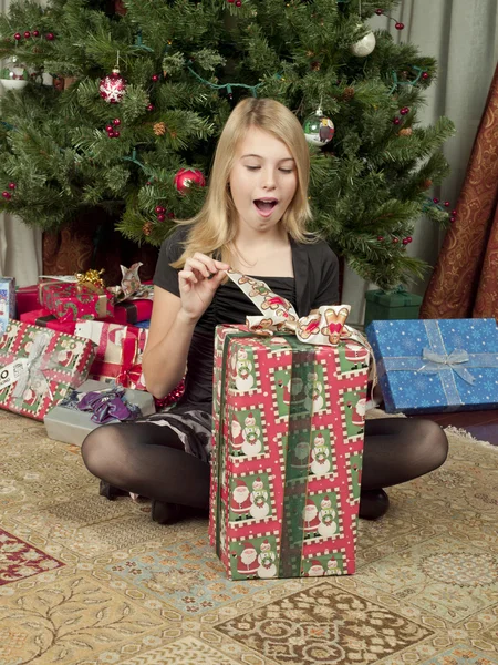 View of a girl with open mouth opening a gift box — Stock Photo, Image