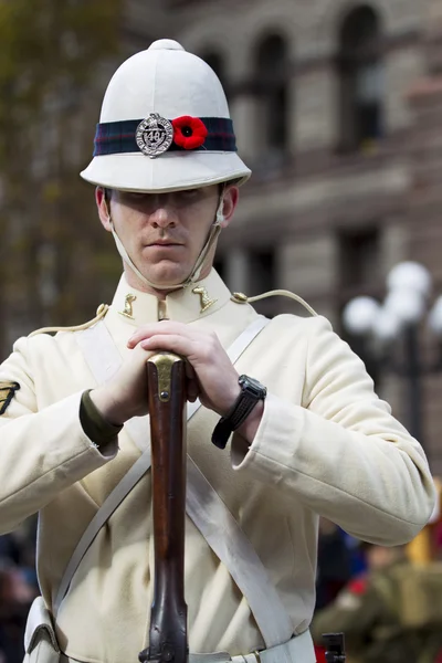 Visa en soldat med gevär med i bakgrunden — Stockfoto