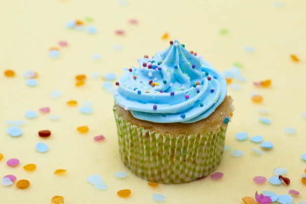Cupcake with blue whipped cream and sprinkles — Stock Photo, Image