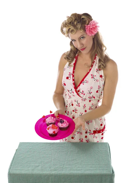 Hermosa joven mostrando un plato de cupcakes de fresa — Foto de Stock