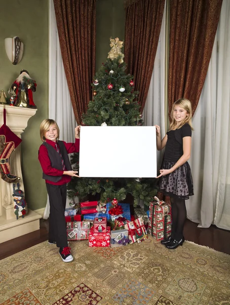 Brother and sister displaying empty billboard — Stock Photo, Image