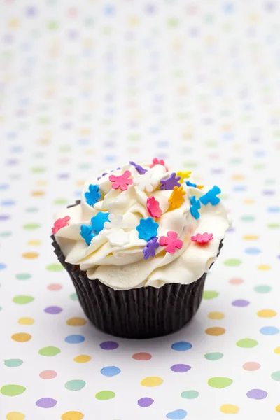 Nära upp skott av en cupcake med färgstarka strössel — Stockfoto