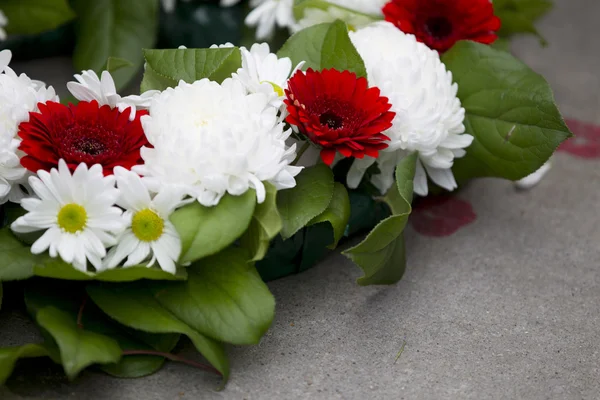 Close up shot of flowers arranged at war memorial — Stock Photo, Image