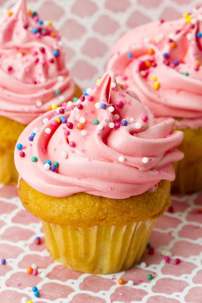 Abgeschnittenes Bild von Erdbeer-Cupcake mit Zuckerguss und Streusel — Stockfoto