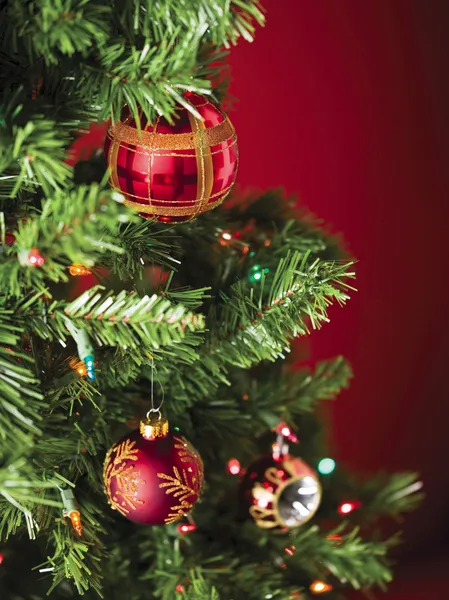 Rote Christbaumkugel mit Weihnachtsbeleuchtung — Stockfoto