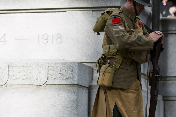 Side view of a soldier with rifle standing by war memorial — Stock Photo, Image