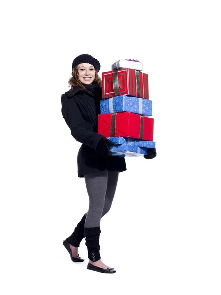 Souriante jeune femme tenant une pile de cadeaux de Noël — Photo