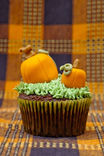 Tasty cupcake decorated with pumpkin miniature — Stock Photo, Image