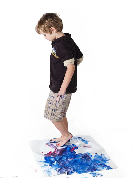 Boy making footprint on piece of paper — Stock Photo, Image