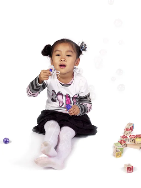 Asian girl playing with bubble wand — Stock Photo, Image