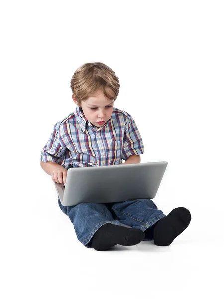 Söt elementära pojke med laptop — Stockfoto