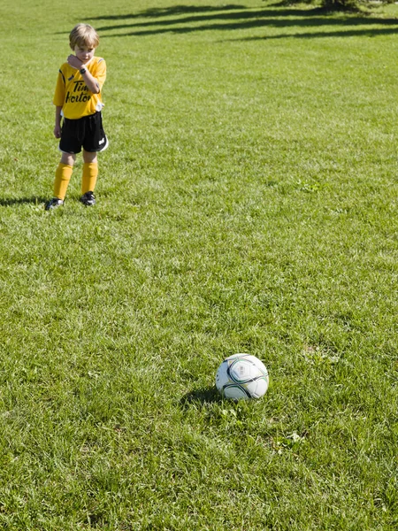 小学生男子プレーヤーのボールをキックする準備ができて — ストック写真