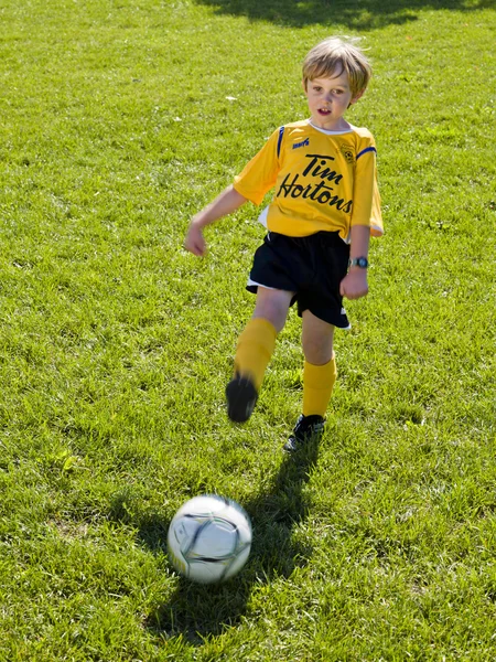 Menino elementar jogando futebol — Fotografia de Stock