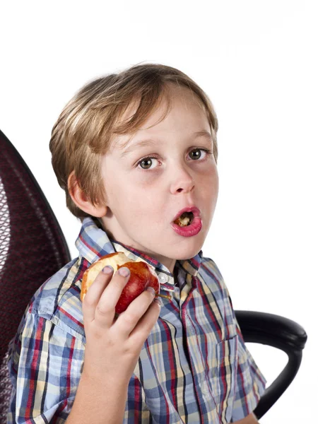 Retrato de um menino elementar comendo maçã — Fotografia de Stock