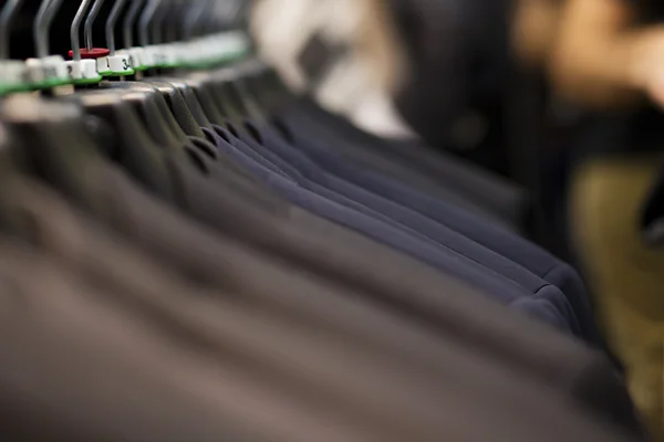 Trajes en perchas en tienda de ropa — Foto de Stock