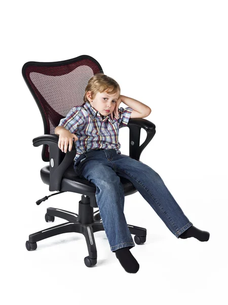 Tired little boy sitting on chair — Stock Photo, Image