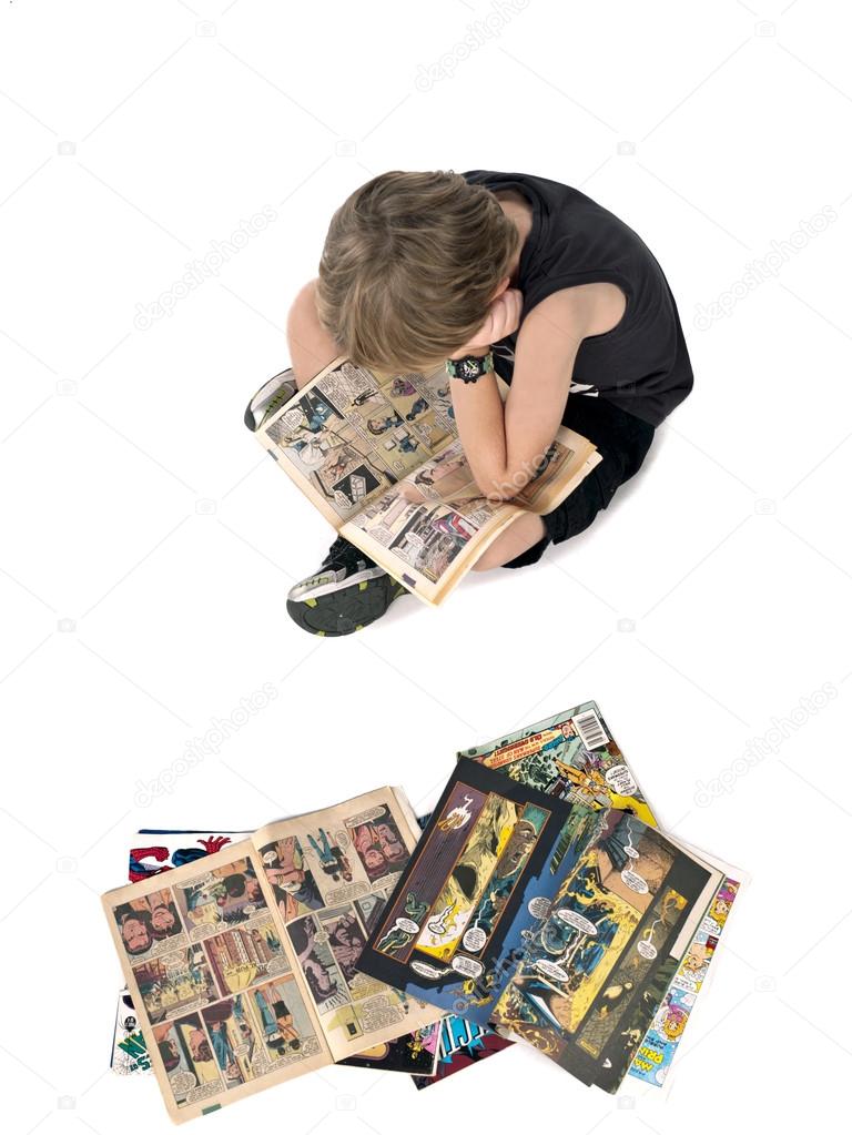 top view of a blonde boy reading comic book