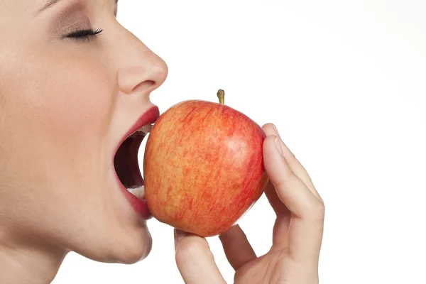 Vrouwen bijten in verse apple close-up op witte achtergrond — Stockfoto