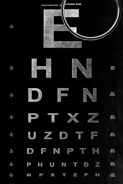 Eye test chart and magnifying glass — Stock Photo, Image