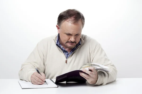 743 mature businessman making notes from a magazine — Stock Photo, Image