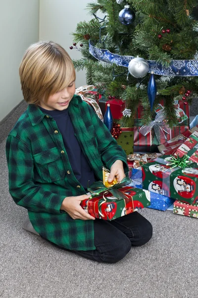 Junge öffnet sein Weihnachtsgeschenk — Stockfoto
