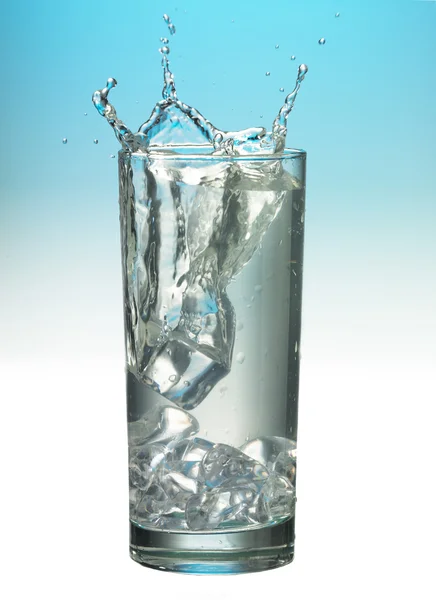Rozpryskiwania szklankę wody z lodem — Zdjęcie stockowe