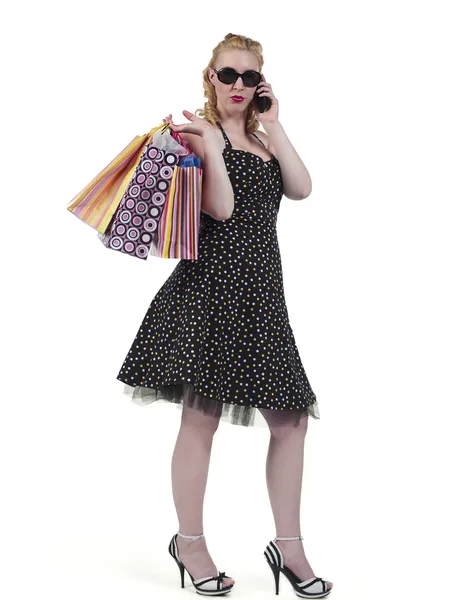 Belle femme avec des sacs à provisions communiquant sur le cellphon — Photo