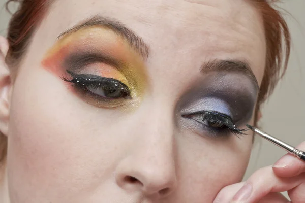 Mujer aplicando sombra de ojos — Foto de Stock