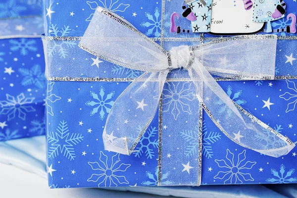 Knot of shiny ribbon on blue christmas gift box — Stock Photo, Image