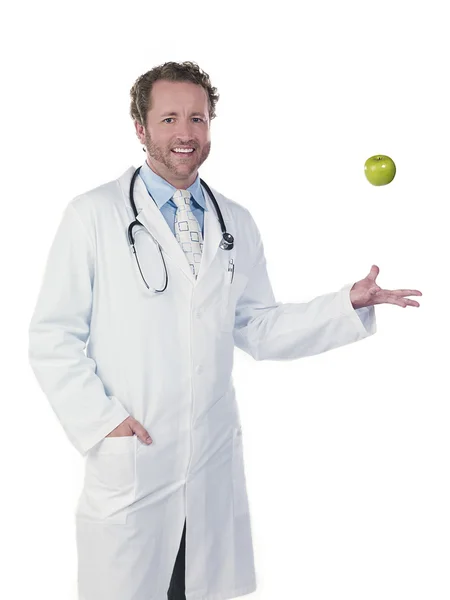 Portret lekarza podrzucając zielone jabłko — Zdjęcie stockowe