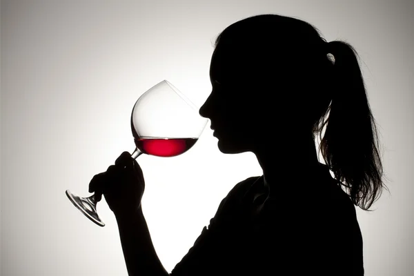 Silhouette di una ragazza che beve vino — Foto Stock