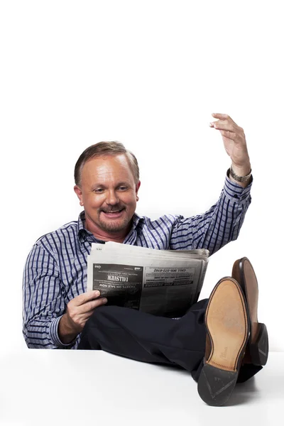 Reifer Geschäftsmann gestikuliert beim Zeitungslesen — Stockfoto