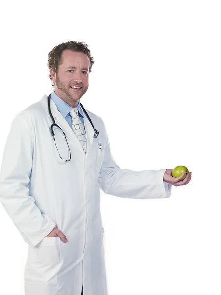 Молодой доктор держит зеленое яблоко — стоковое фото