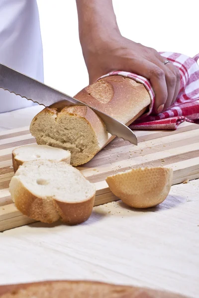 A baker slicing a baguette roll — Stock Photo, Image