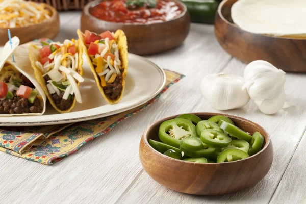 En skål med en bit grön paprika med tacos i bakgrunden — Stockfoto