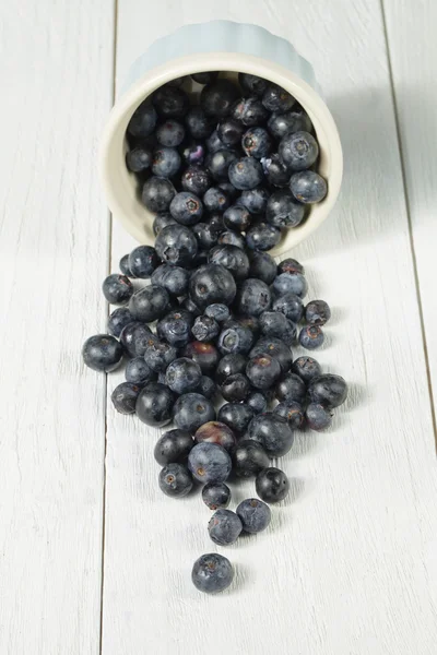 A bowl with spilled blueberries — Stockfoto