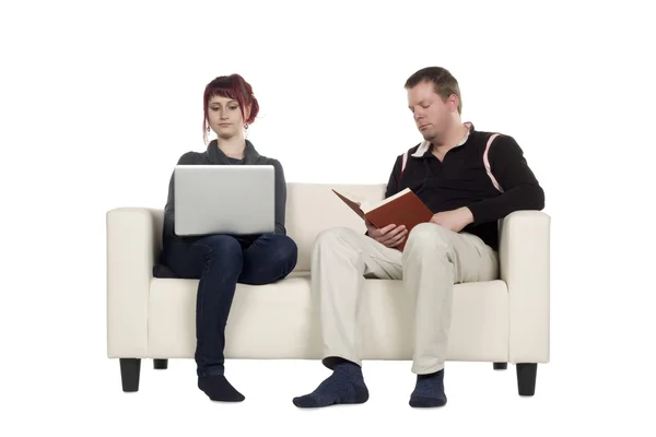 Um casal ocupado sentado no sofá — Fotografia de Stock