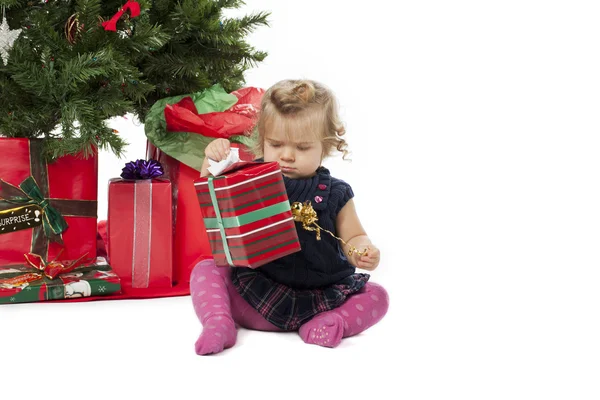 Blick auf ein süßes Mädchen, das eine Weihnachtsgeschenkschachtel öffnet — Stockfoto