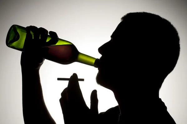 Silhouet van de mens het drinken van wijn met sigaret — Stockfoto