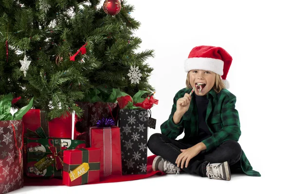 Junge isst Weihnachtsbonbons — Stockfoto