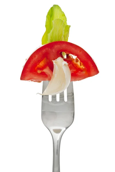 Un tenedor con una rebanada de lechuga de tomate y ajo — Foto de Stock