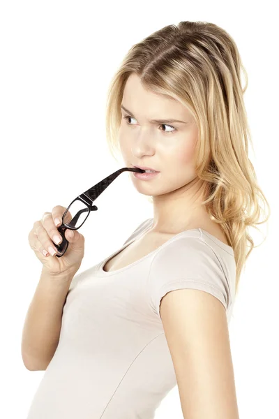 A lady biting the handle of her eyeglasses looking on the side — Stock Photo, Image