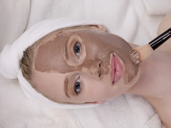 En dam som tillämpar lera mask av en cosmetician — Stockfoto