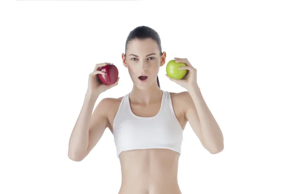 Una mujer deportiva sosteniendo manzana roja y verde — Foto de Stock