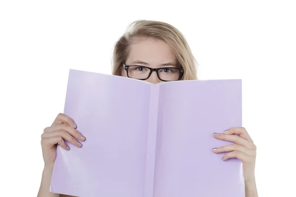 Uma mulher segurando livro cobrindo seu rosto — Fotografia de Stock