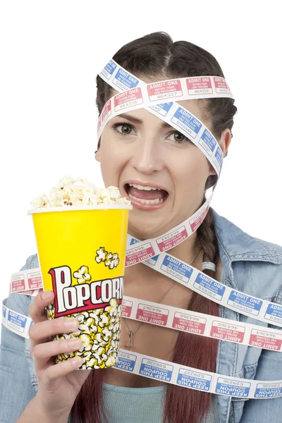 Женщина, держащая в руках кукурузу и обмотанная билетами в кино — стоковое фото