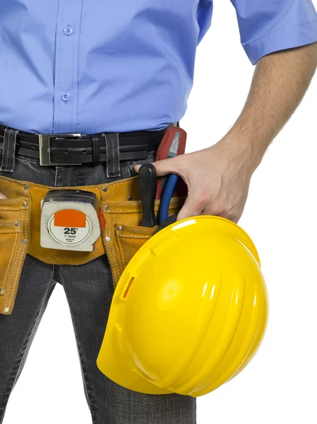 Um trabalhador com capacete amarelo e ferramentas de construção — Fotografia de Stock