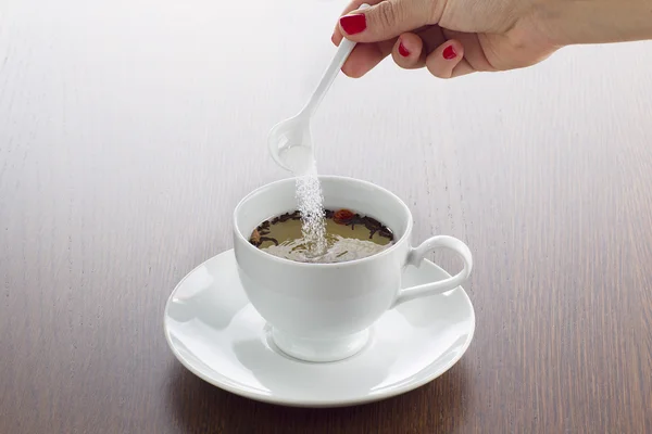 Zucker in Tasse Tee geben — Stockfoto