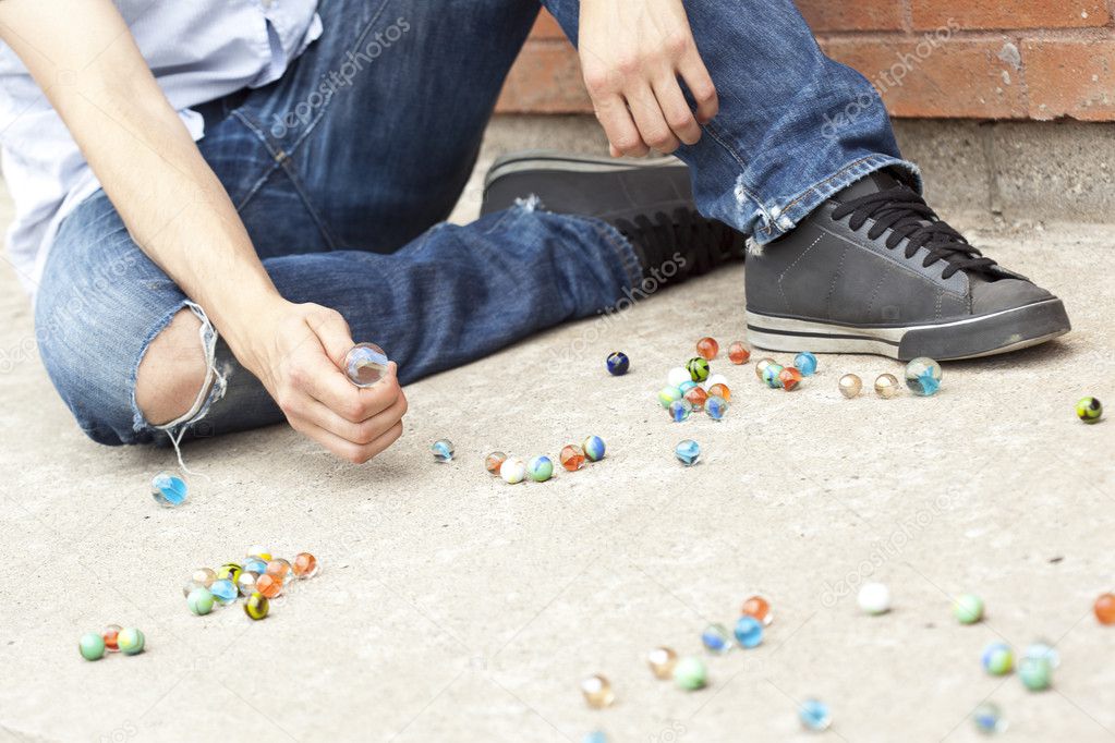 a boy playing marbles on the street